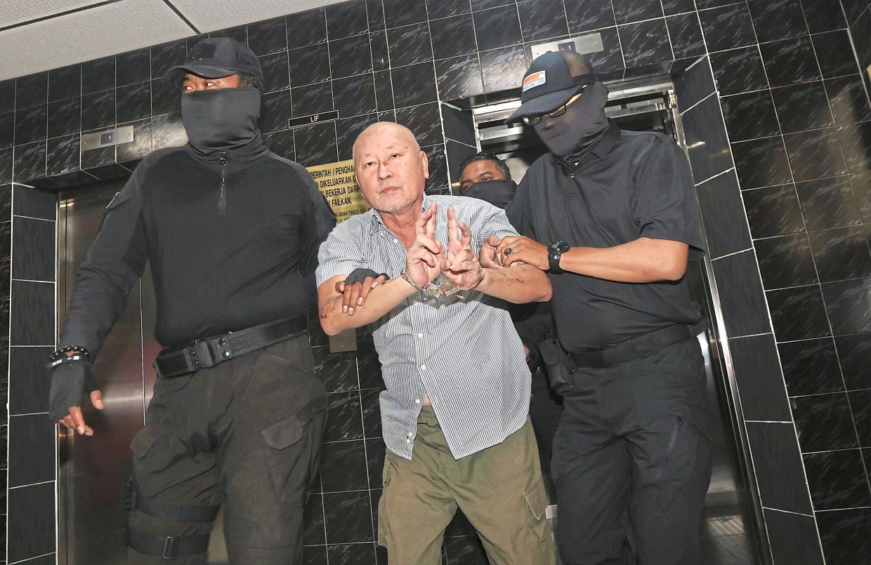 Murder accused flashes peace sign before hearing