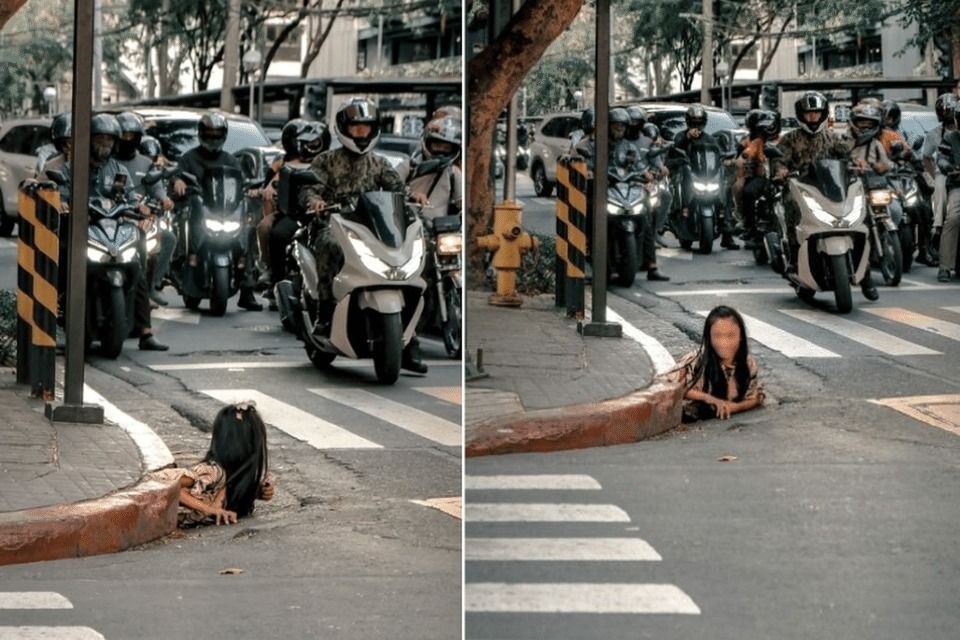 In macabre street scene, woman in the Philippines crawls out of storm drain