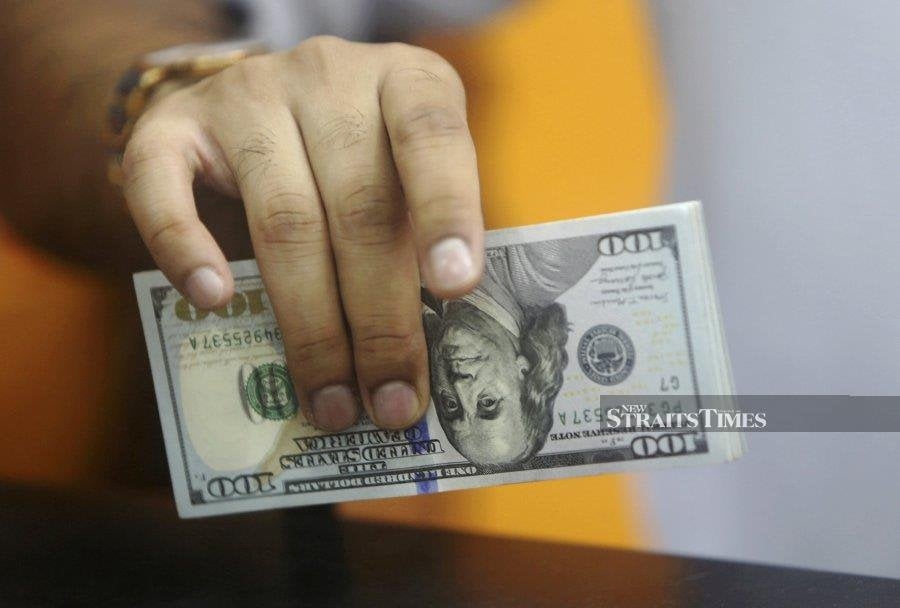 Dollar slides on easing trade tensions, Fed expectations