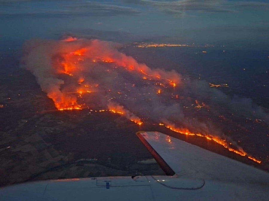 One dead, thousands evacuated as wildfires rage in France and Spain