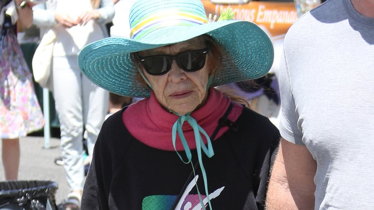 Legendary comedienne, 91, looks frail as she holds hands with a much younger man at a market