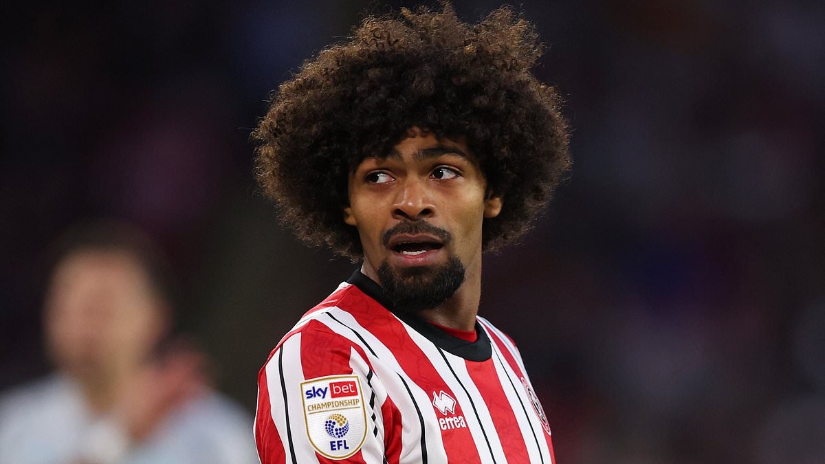 Sheffield United star has to be held back as rival players clash during pitch invasion - after Burnley are promoted back to the Premier League