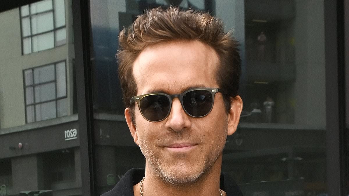 Ryan Reynolds is a surprise guest at iconic rock group's Walk of Fame ceremony after being mocked by fans