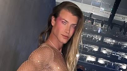 Christian Wilkins leaves very little to the imagination as he slips into a completely see-through dress at Kylie Minogue concert