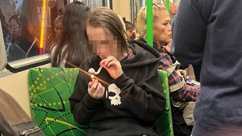Disgusting moment man smokes a 'crack pipe' on packed Melbourne tram