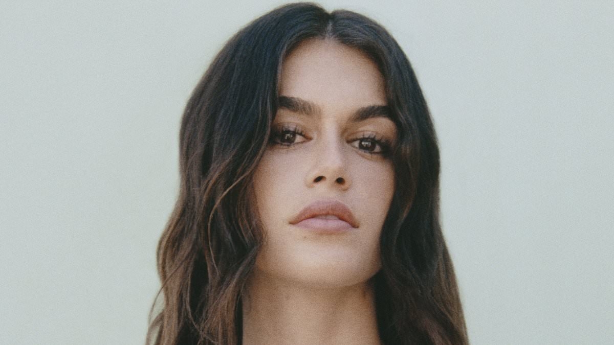 Kaia Gerber shows off her supermodel frame as she slips into a VERY plunging brown dress while modelling her new Capsule collab with Mango