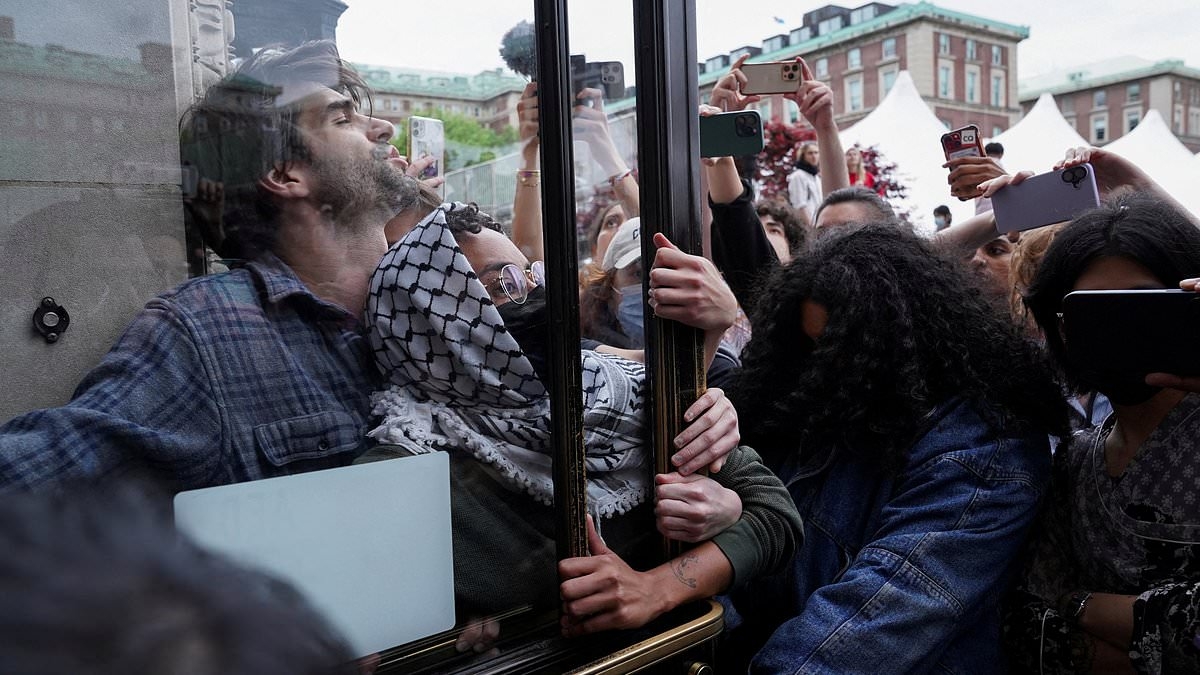 Anti-Israel protesters wearing keffiyehs and masks are locked inside library at Columbia University in stunt gone wrong