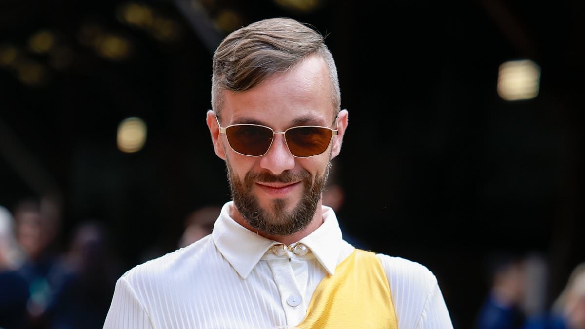 Dressed in the dark? Controversial influencer dons Gen Z 'maximalist' trend at Australian Fashion Week with two dresses layered on top of each other - after showing up in wedding gown held up by four assistants