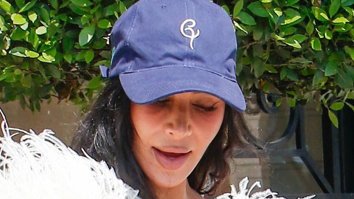 Kim Kardashian makes bizarre fashion choice as she teams busty feathered gown with a baseball cap for lunch with suited and booted Kris Jenner after testifying in jewellery heist trial