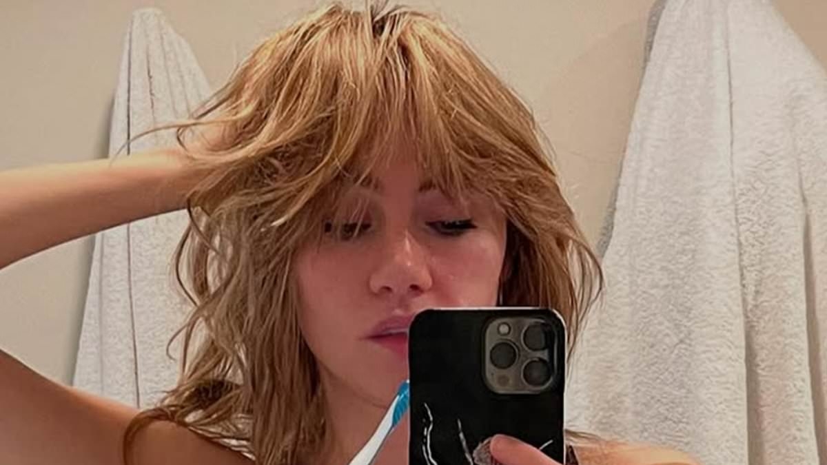 Suki Waterhouse displays impressive abs in mirror snap after sporting huge pair of prosthetic breasts for Pamela Anderson-inspired music video