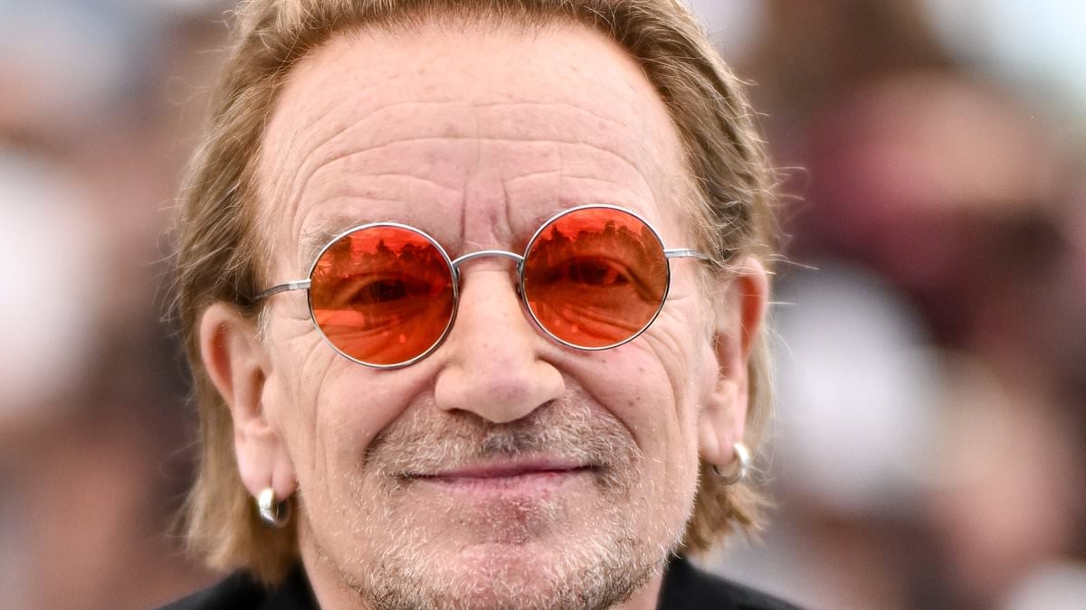 Proud Bono grins as he arrives at a special screening of his documentary Bono: Stories of Surrender at Cannes Film Festival - after it got seven-minute standing ovation at premiere