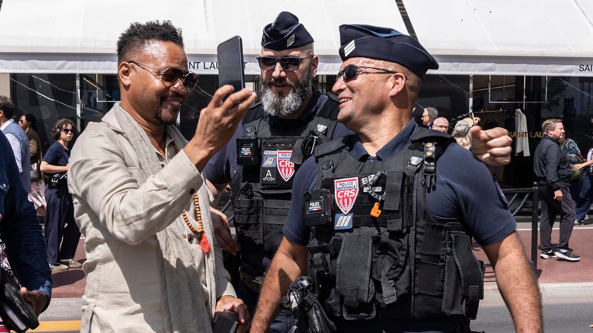 Show me the camera! Cuba Gooding Jr poses for a selfie with two French police officers as he unwinds at the 79th Cannes Film Festival