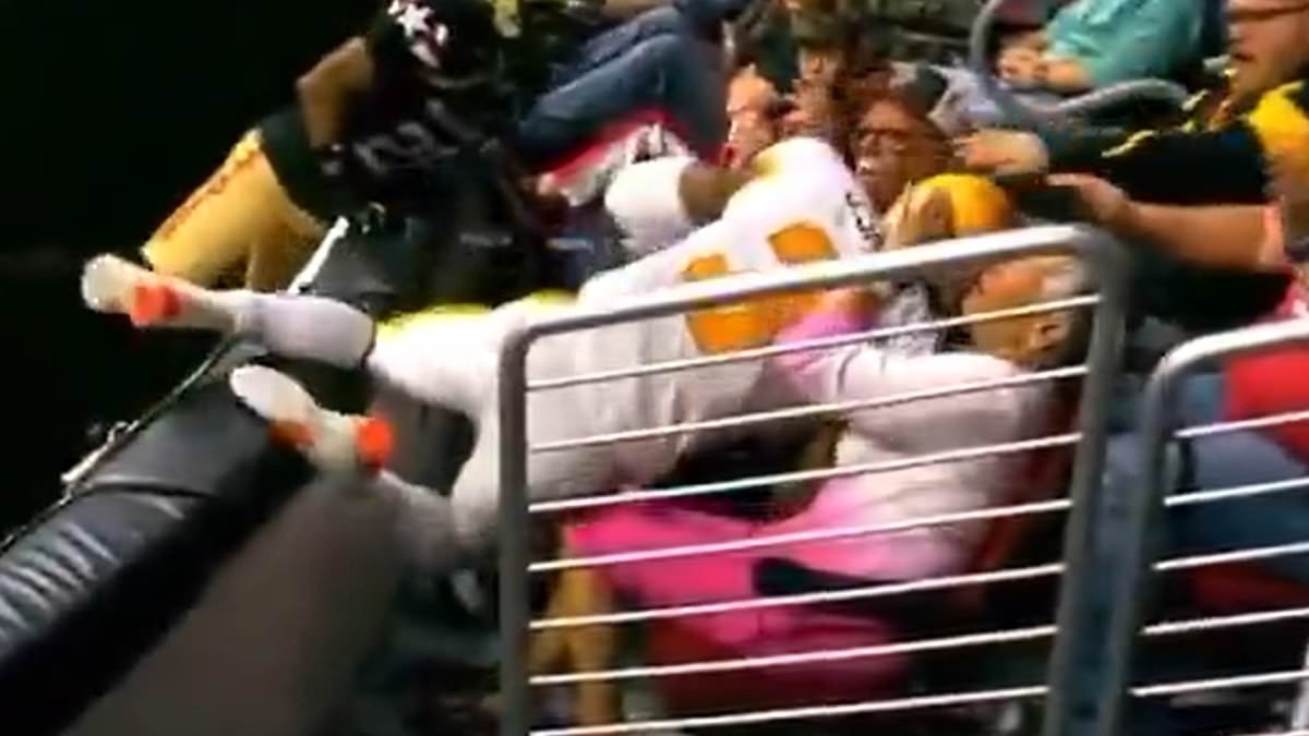 Dangerous moment football player crashes into fan after leaping over barrier to make crucial touchdown