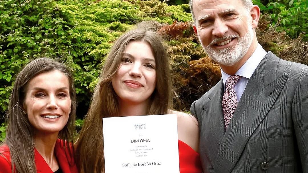 King Felipe and Queen Letizia of Spain play proud parents as they hug Infanta Sofía, 18, on her graduation day from 'hippie Hogwarts' school