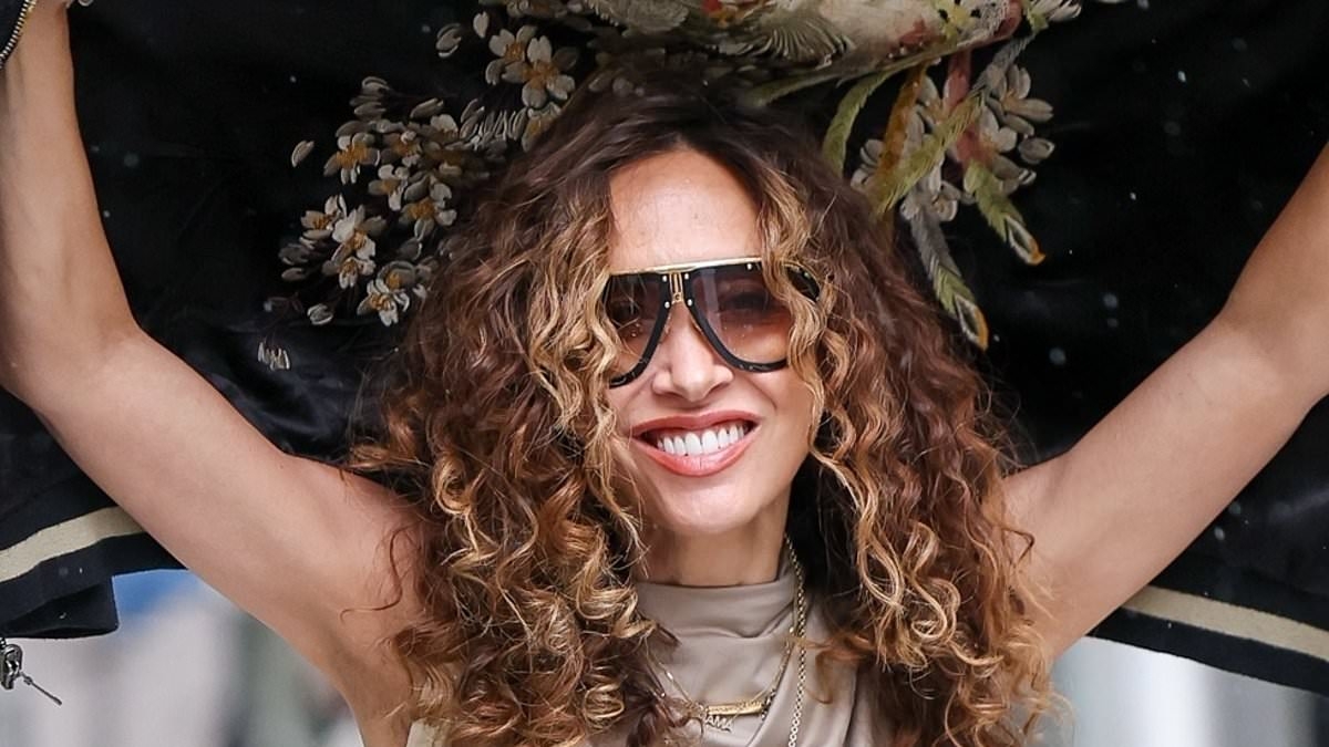 Myleene Klass risks ruining her curly hair as she gets caught in the rain outside Smooth Radio