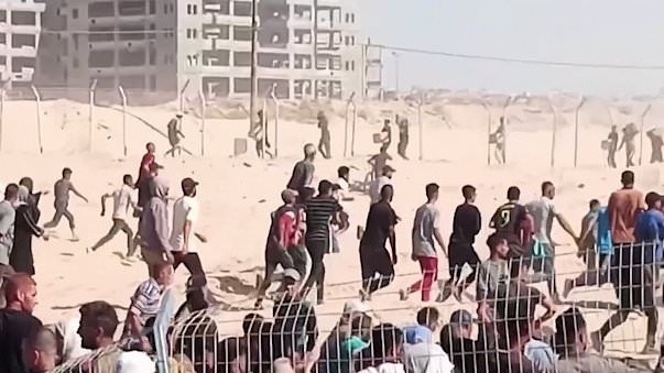 Thousands of Palestinians storm aid distribution sites in Gaza, with fences torn down amid desperate bid for food