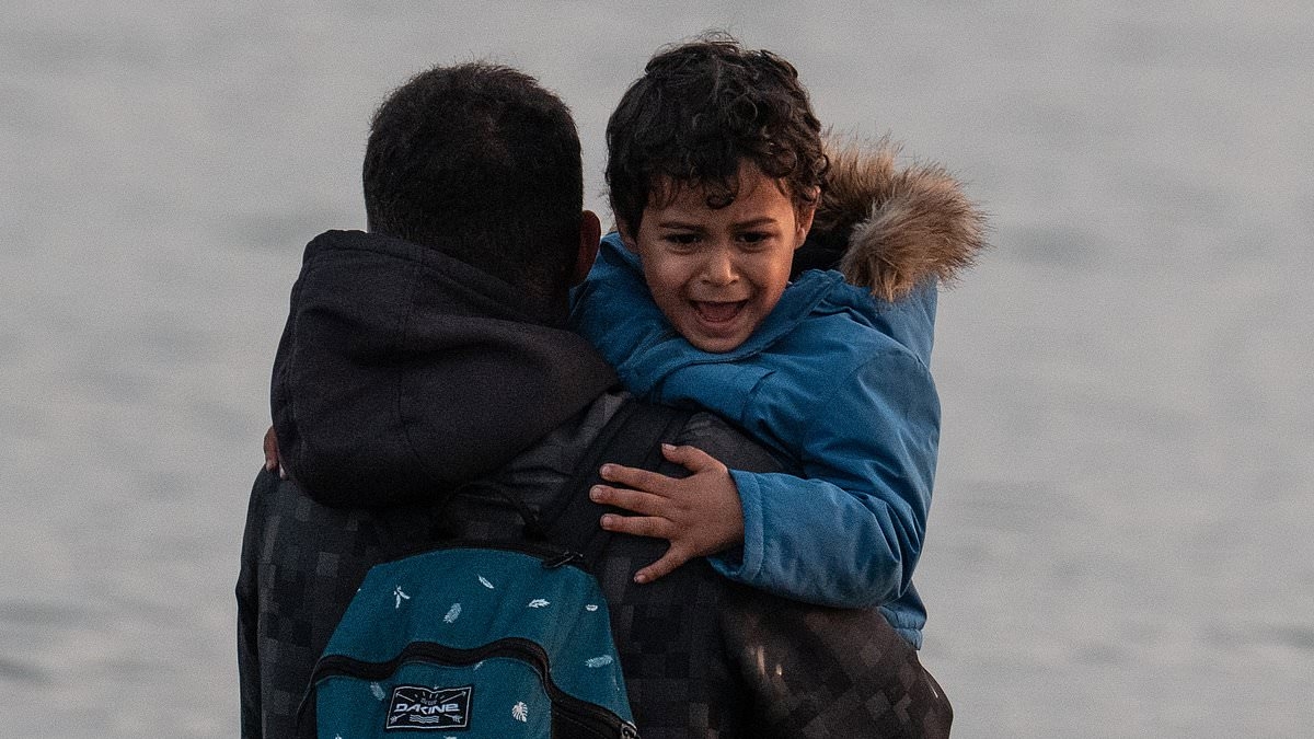 French police stand back and watch as migrant families including small children pack themselves onto small boats heading across the Channel to the UK