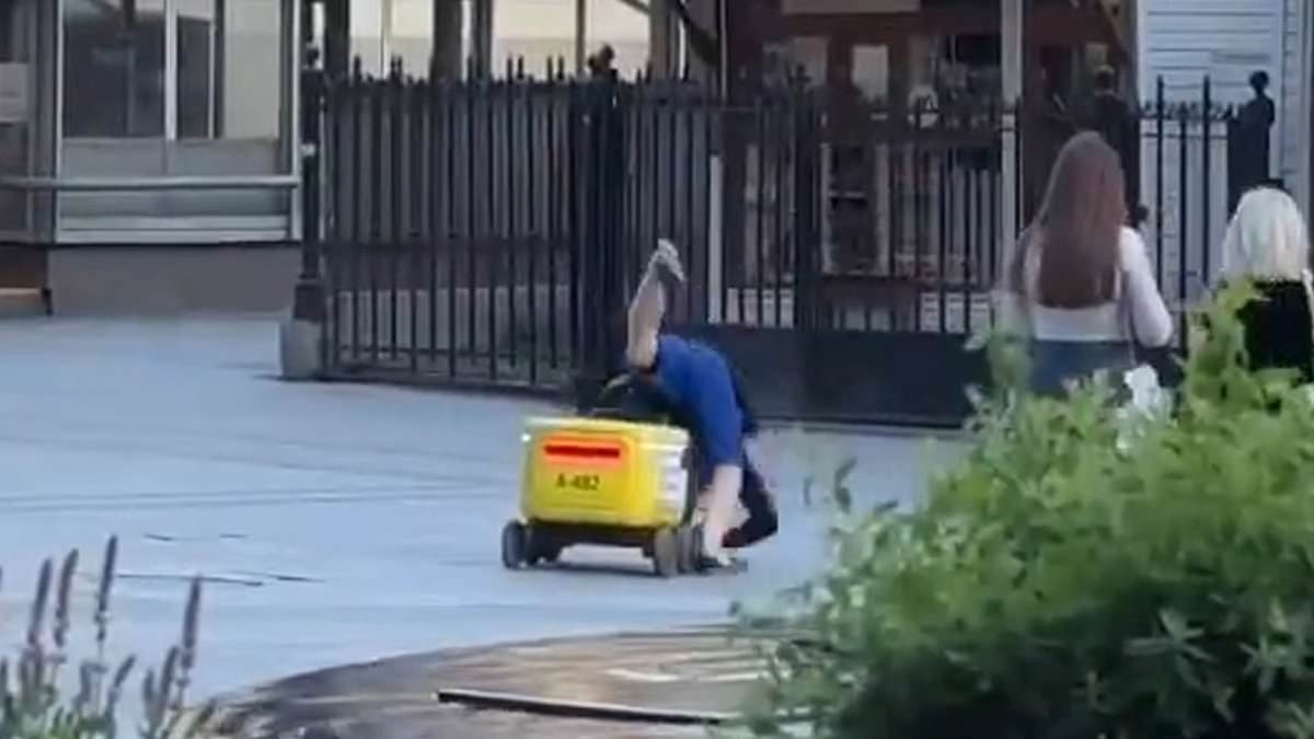 Watch the moment a 'drunk' Russian tries to ride delivery robot… before he's thrown off by the machine