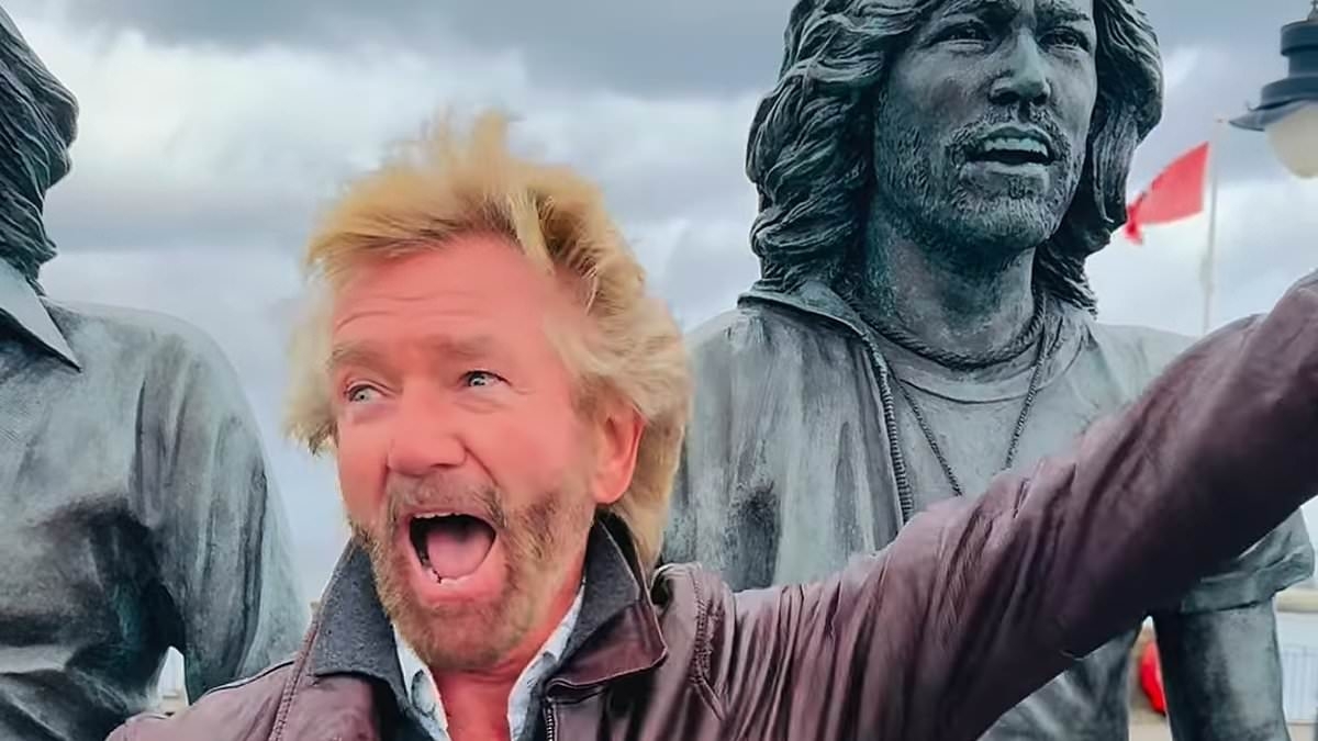 Noel Edmonds spotted once again wearing ODD shoes as he puts on a kooky display while dancing alongside statue of the Bee Gees on the Isle of Man - ahead of his '£1M' return to TV