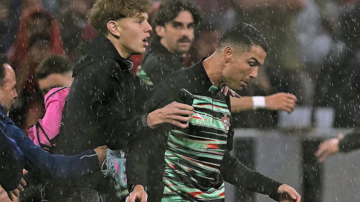 Cristiano Ronaldo grabbed by pitch invader ahead of Portugal's clash with Germany - as stewards are forced to step in after security breach