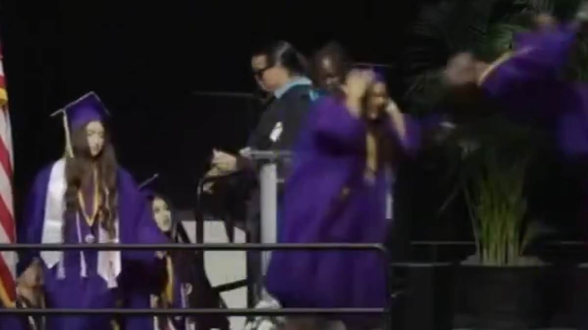 High school graduate kicks another student in the face as he pulls a surprise stunt while accepting diploma
