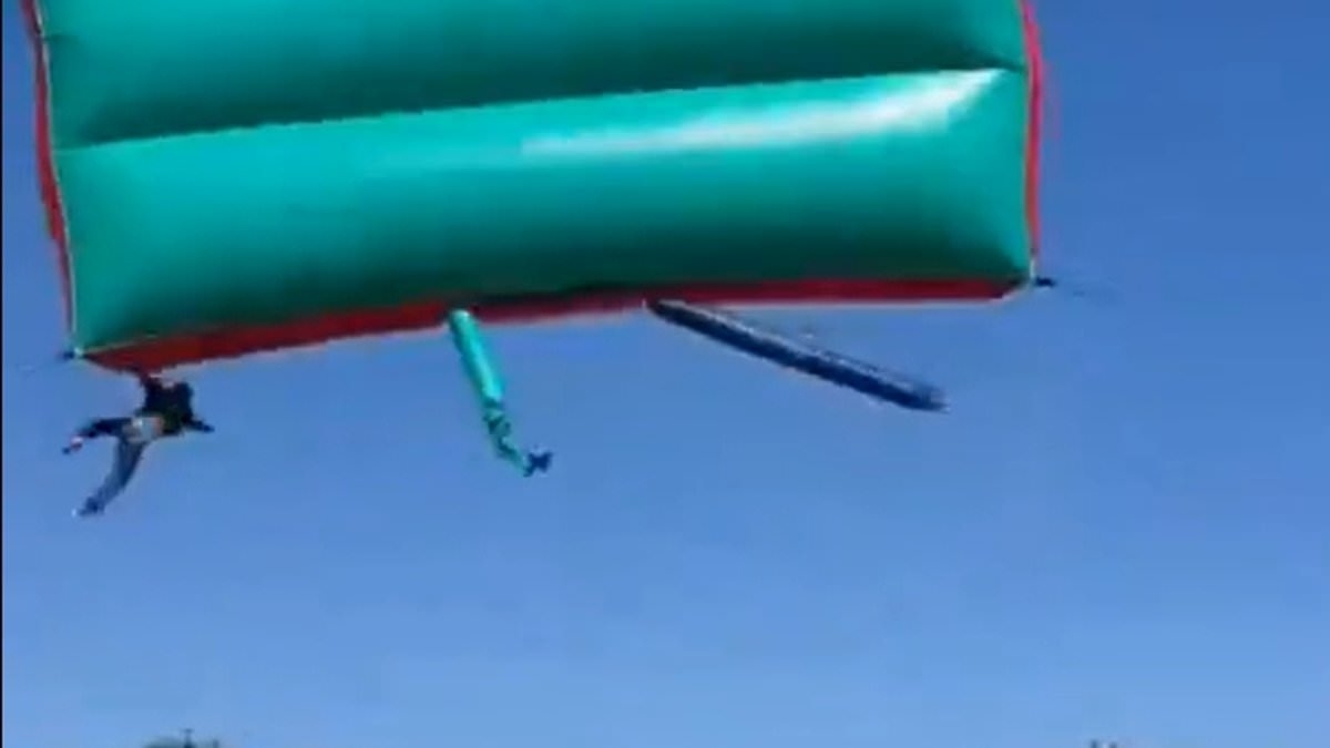 Terrifying moment two children cheat death after falling from bouncy castle blown 40 feet into the air during school fund-raiser
