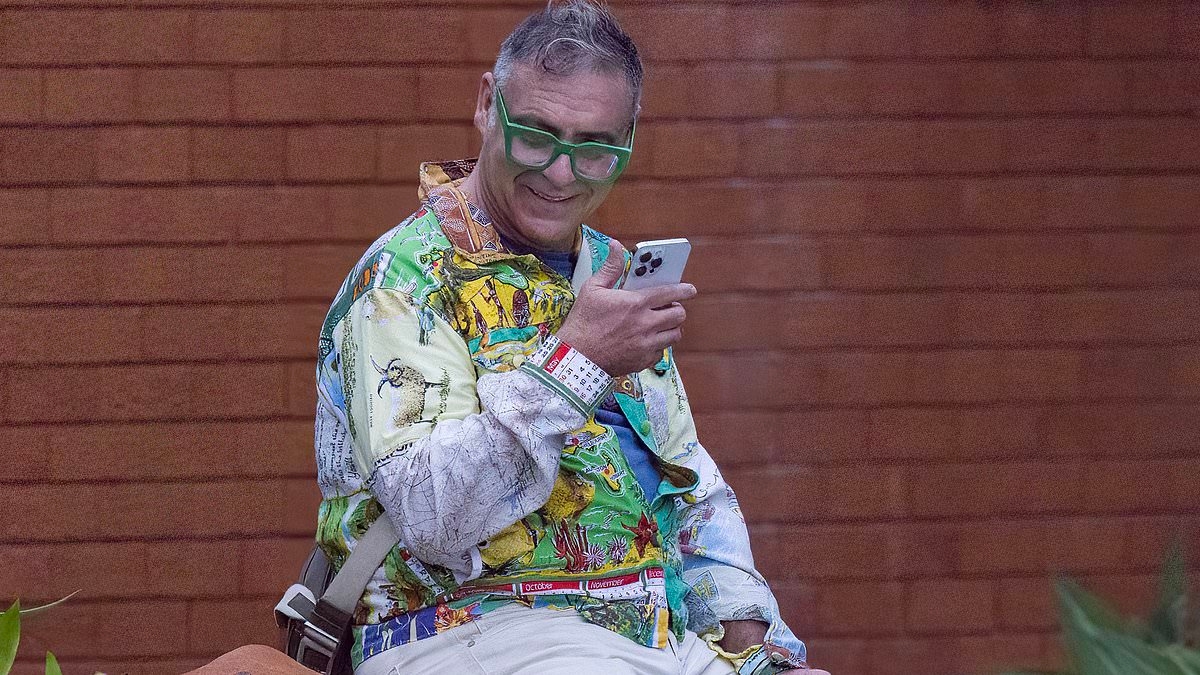 Andrew O'Keefe cuts a colourful figure as he steps out for a cigarette in Bondi...after the disgraced former Seven star was ordered to enter rehab