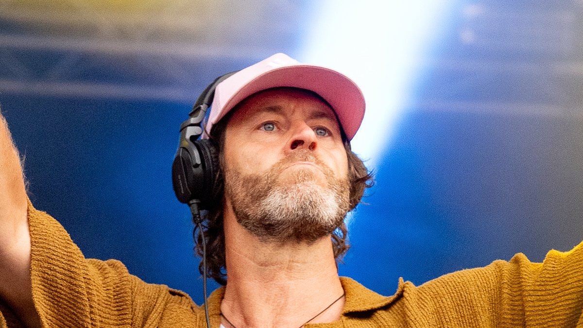 Take That star cuts a casual figure in a mustard shirt and peach shorts as he unveils surprise new career at Cheshire Oaks' 30th anniversary gig