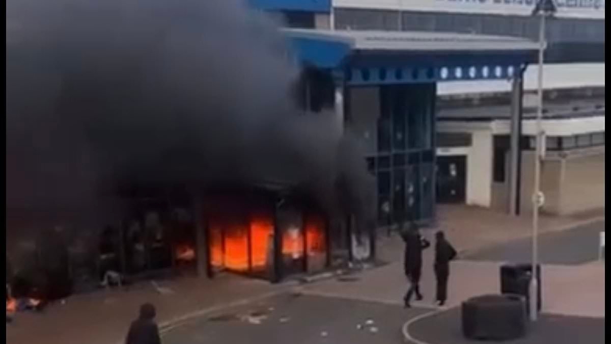 'Anti-migrant' tensions come to a head as leisure centre housing families is attacked by 'racist thugs' in Northern Ireland: Water canons blast yobs after another night of petrol bombs and fireworks being lobbed at cops