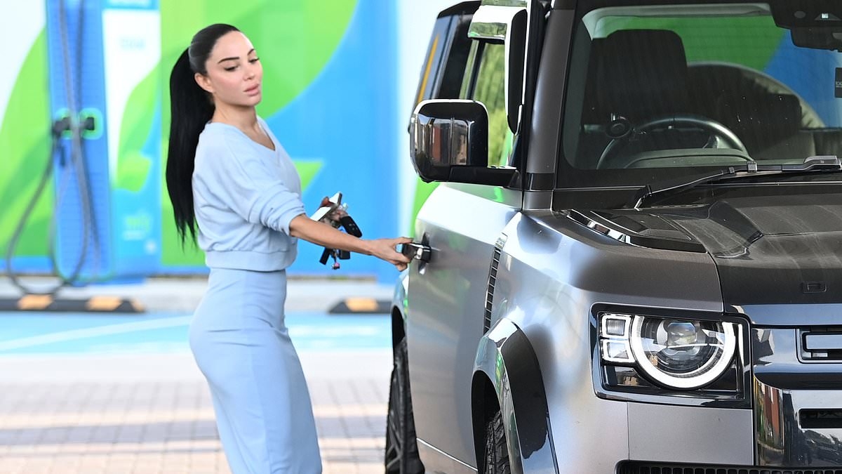 Tulisa shows off her figure in a pale blue midi skirt as she takes her brand new £148,000 Land Rover for a spin in Manchester