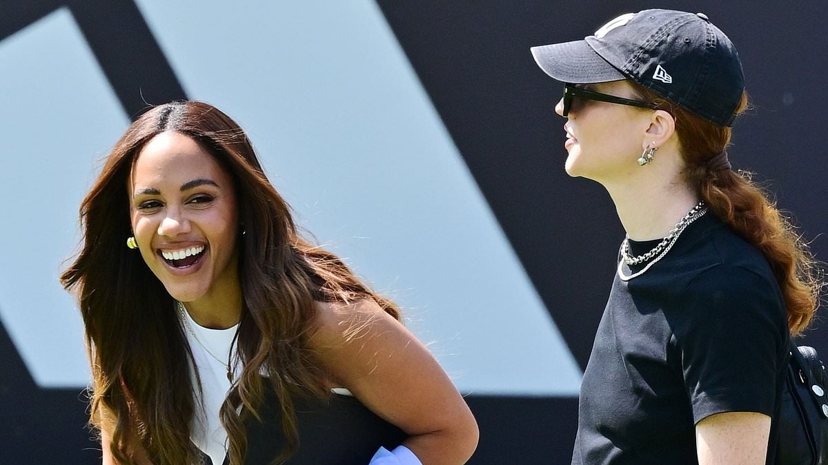 Alex Scott beams while Jess Glynne shows off her ball skills in front of her footballer girlfriend as the couple watch a Soccer Aid training session