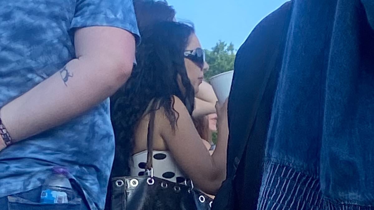 Charli XCX goes unnoticed at Lido Festival as she smokes a cigarette and cheers in the crowd while watching acts ahead of her headline show