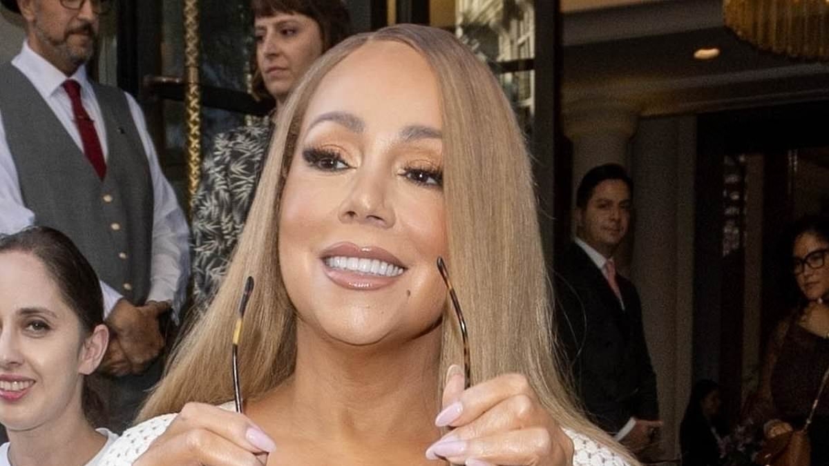 Mariah Carey displays her jaw-dropping curves in a figure-hugging white crochet dress as she leaves her hotel in London