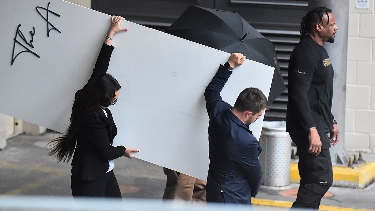 Chris Brown tries desperately to hide his face as he returns for show in Manchester a month after being arrested in the city over alleged nightclub bottle attack