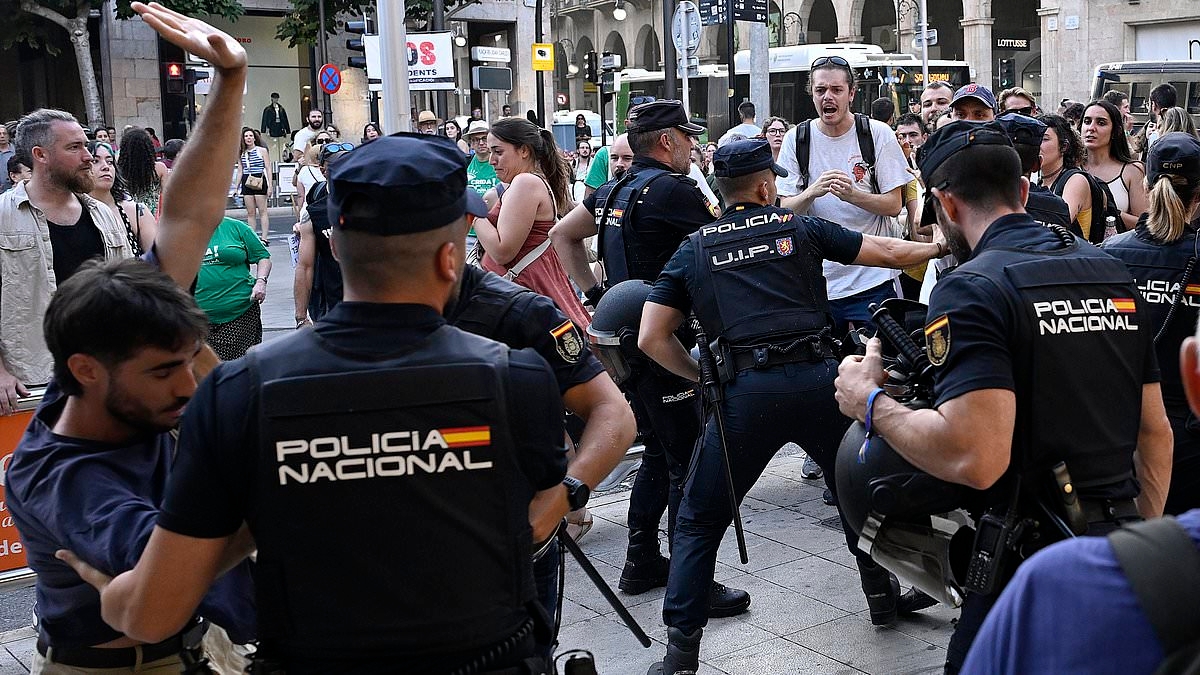 Shocking moment police scuffle with anti-tourist protesters yelling abuse and waving an AXE at diners in a Majorca restaurant during latest demonstrations aimed at holidaymakers