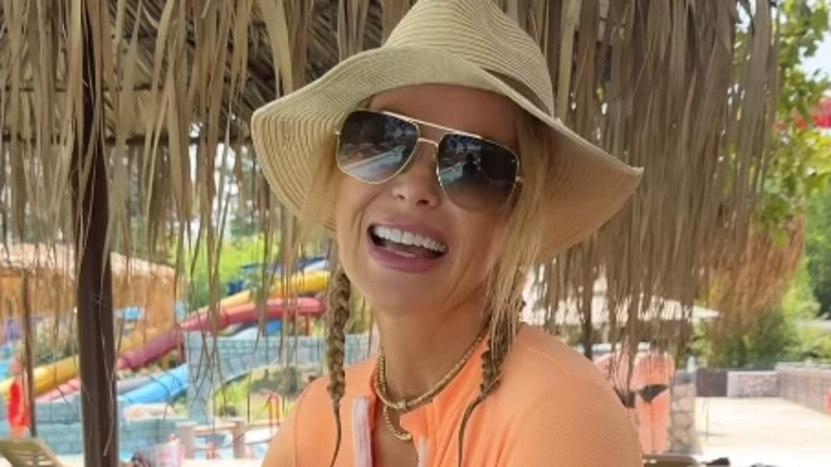 Amanda Holden looks incredible in a plunging swimsuit as she larks around with Alan Carr in Corfu