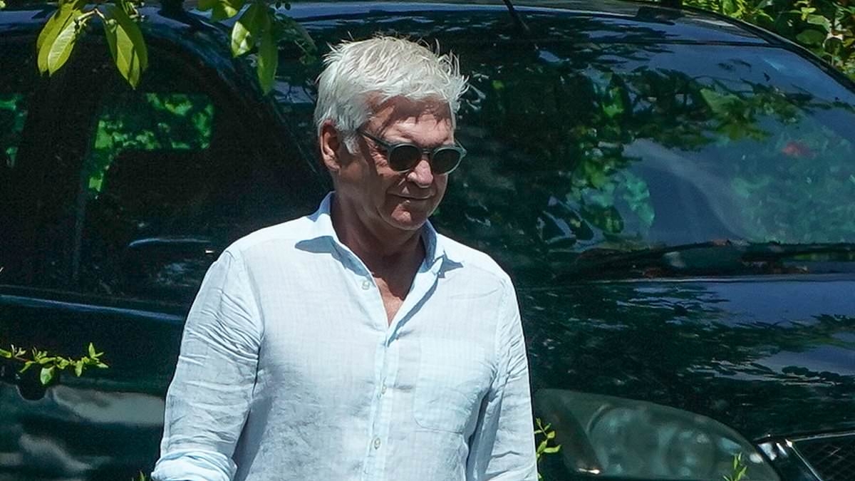 Phillip Schofield makes the most of the summer sunshine as he takes his dog for a walk in London