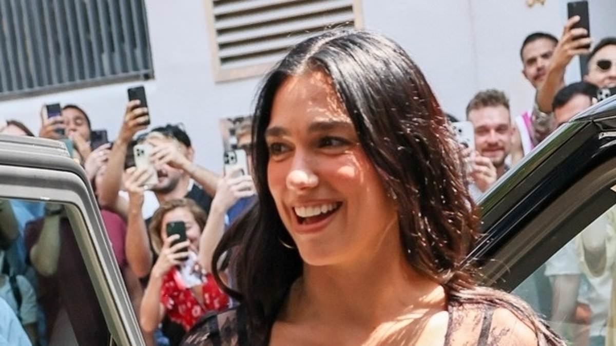 Dua Lipa sets pulses racing in a sheer black lace mini dress as she greets fans at the opening of her merchandise pop-up shop in London