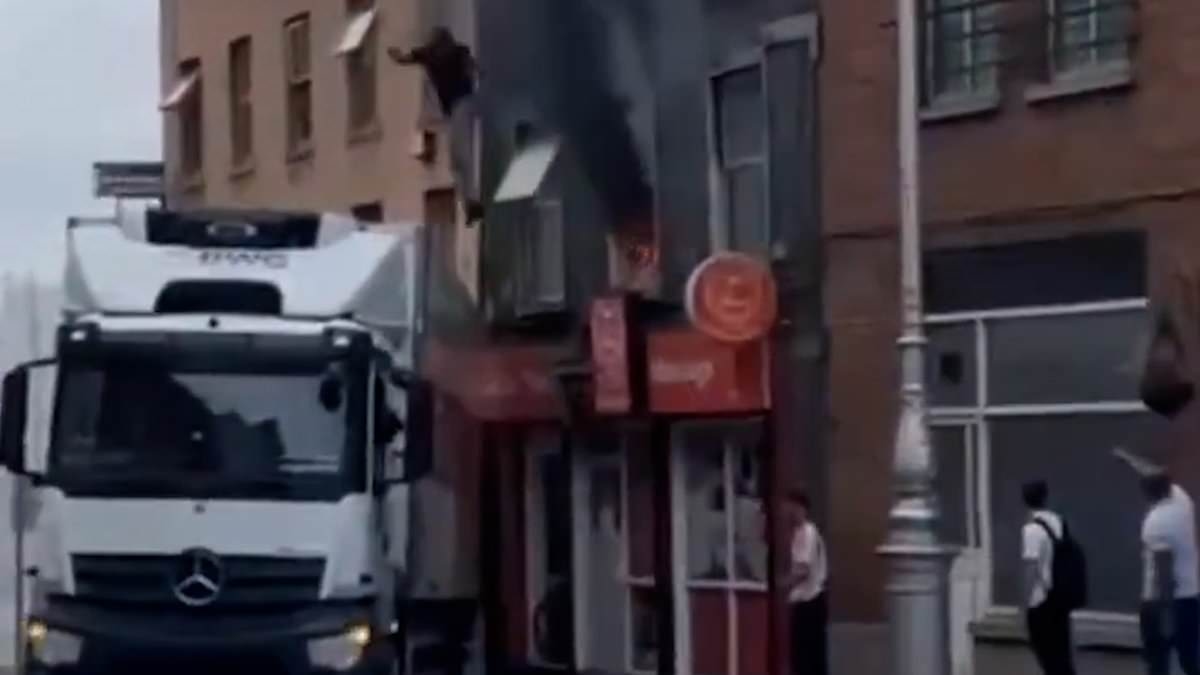 Incredible moment hero lorry driver SAVES person from burning building as smoke pours from windows