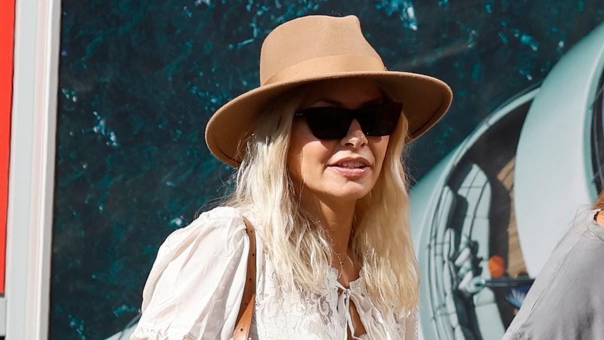 Smiling Holly Willoughby looks festival ready in a white mini dress and brown hat as she flies to Glastonbury
