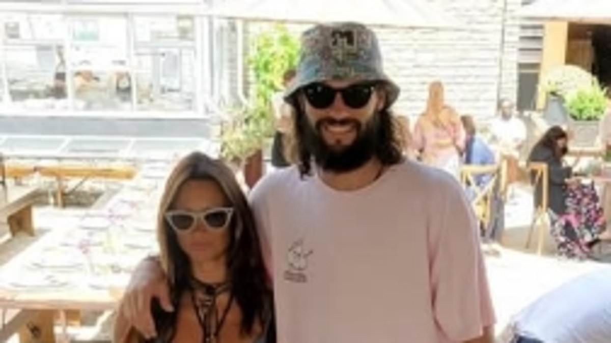 Andy Carroll and Lou Teasdale put on a loved-up display as they watch Lewis Capaldi perform at Glastonbury - after 'friends' fears relationship won't last'