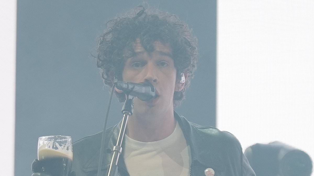 Matty Healy smokes a cigarette and drinks a pint of Guinness before calling himself his generation's 'best songwriter' as he takes to the stage for The 1975's Glastonbury headliner set