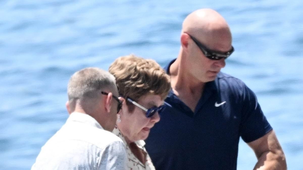 Sir Elton John is assisted off a boat in Italy before enjoying Al fresco meal with husband David Furnish after seemingly picking a side in Beckham family feud
