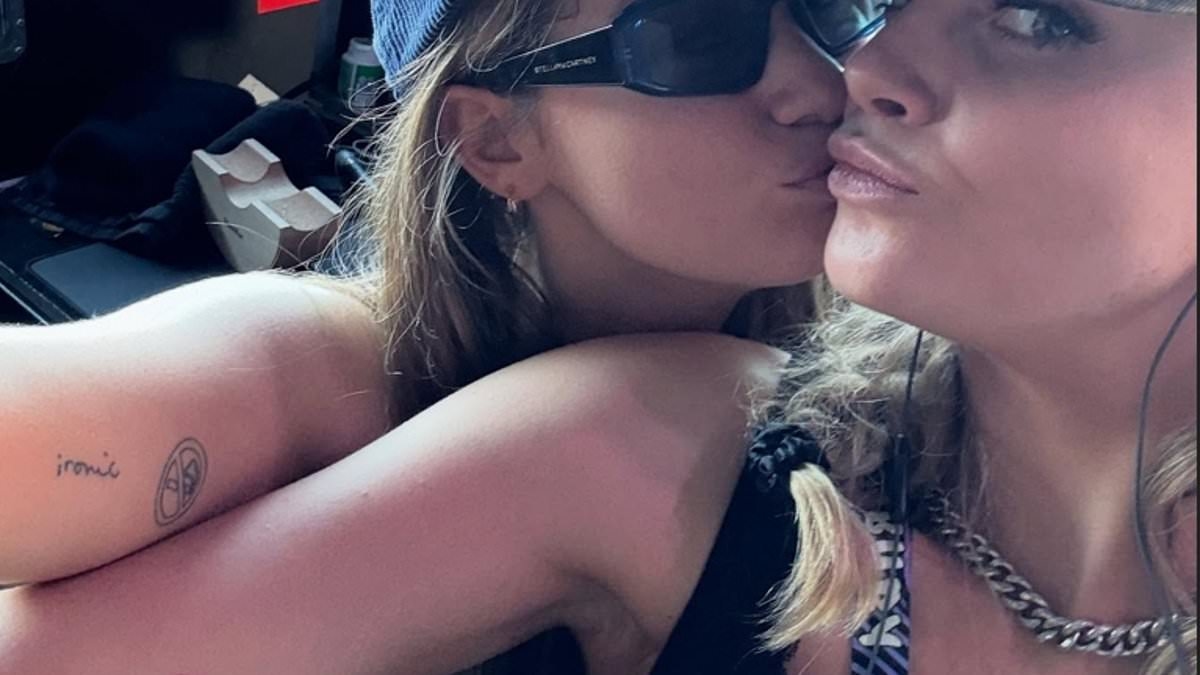 Cara Delevingne kisses girlfriend Minke and shows off their matching Alanis Morissette's tattoos while side-stage for the rock star's Glasto gig