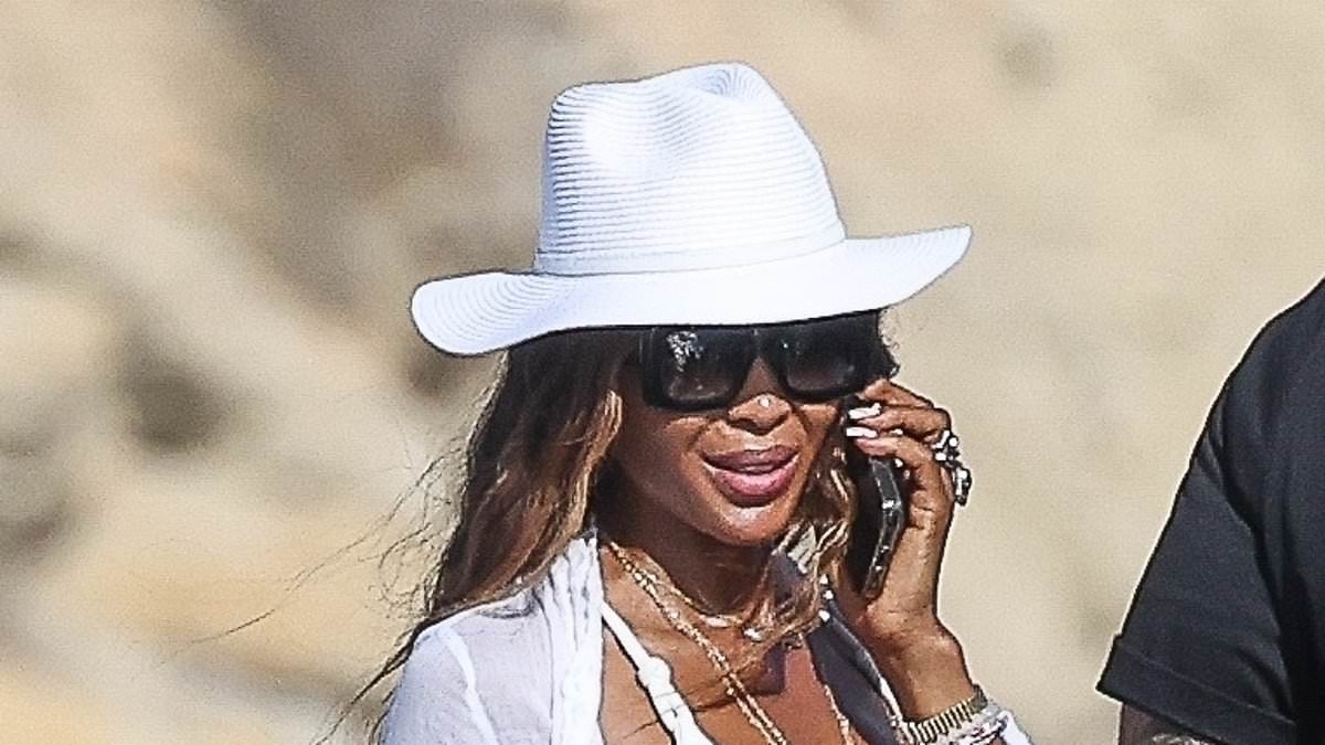 Naomi Campbell, 55, shows off her model figure in a white bikini as she enjoys a beach day in Ibiza