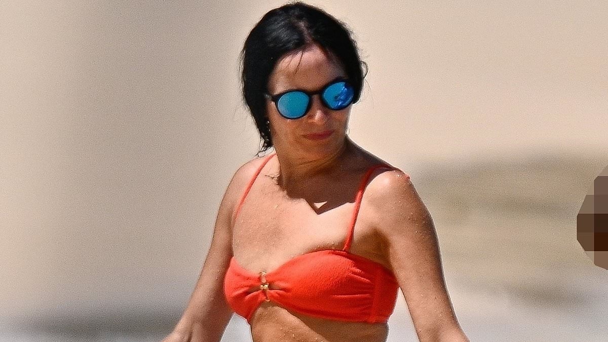 Andrea Corr, 51, shows off her age-defying figure in a skimpy orange bikini as she enjoys a dip in the ocean in Barbados
