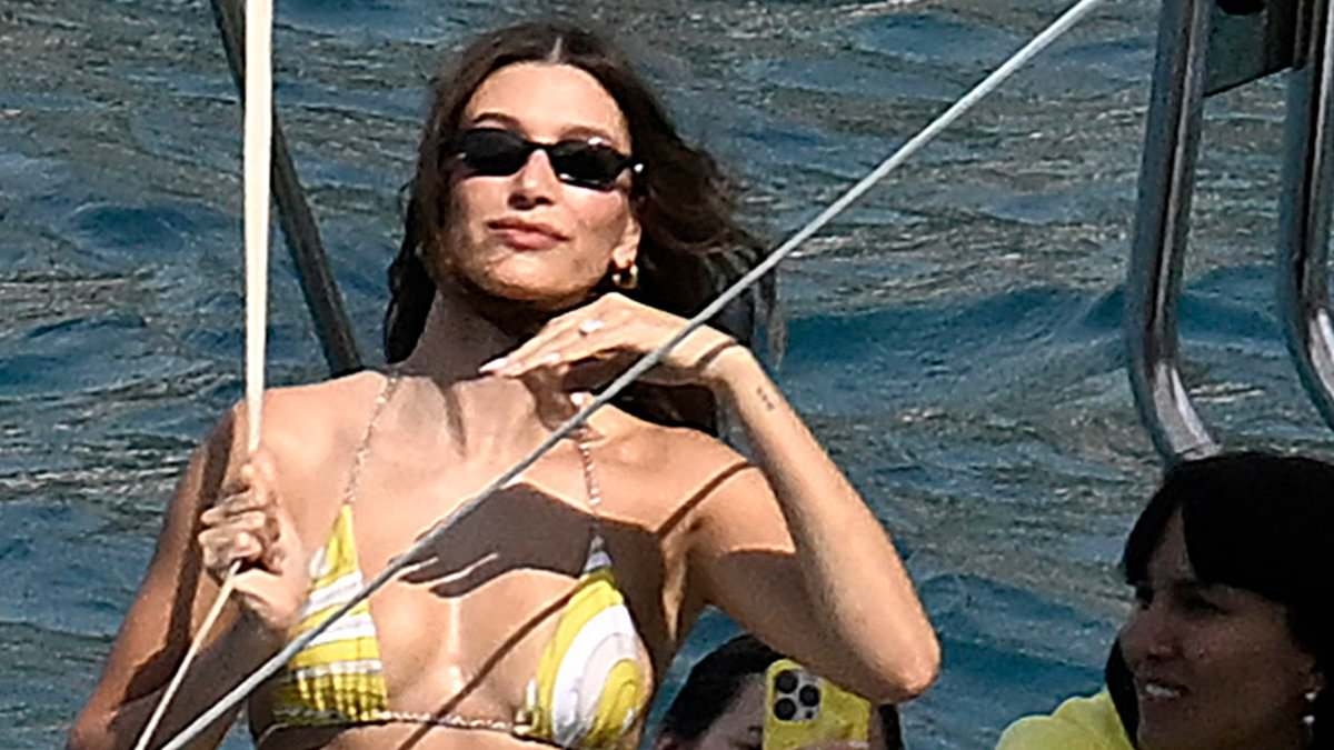 Hailey Bieber wows in skimpy bikini as she soaks up the sun in Majorca after hitting back at 'losers' who fuelled marriage trouble rumours as she promotes Justin's new album