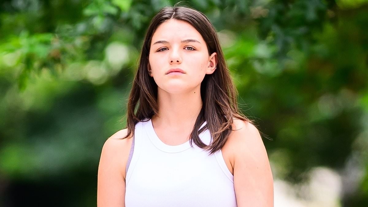 Suri Cruise, 19, debuts a belly button piercing when in a crop top... after finishing her first year of college