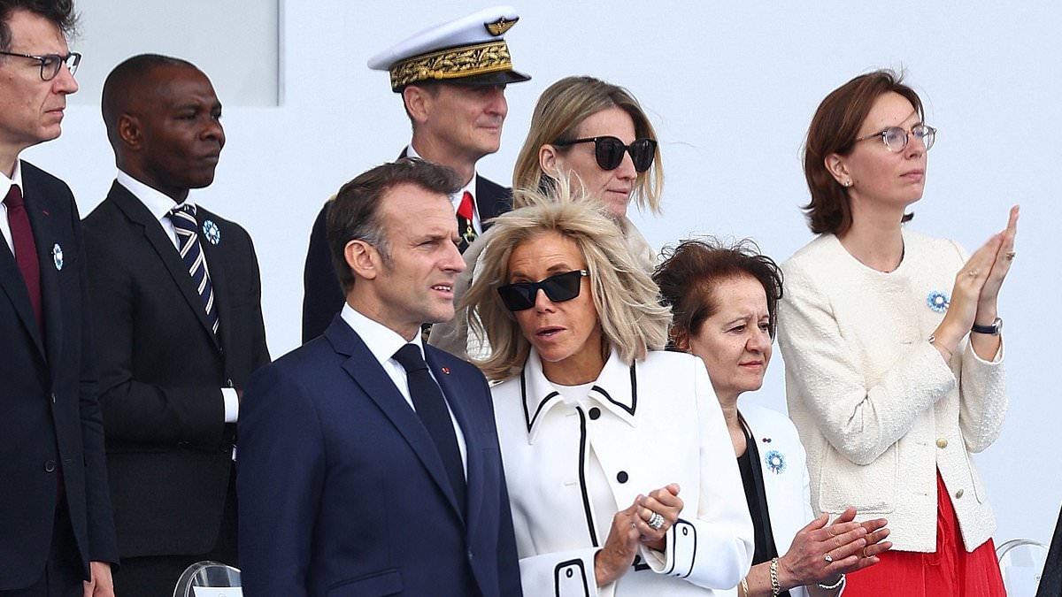 Brigitte Macron puts on a brave face as she joins husband Emmanuel for French Bastille Day celebrations as furore over ludicrous claim she is actually a man continues