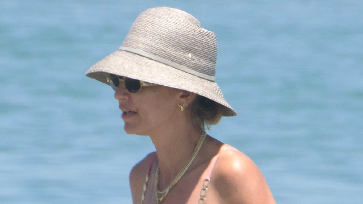Vogue Williams shows off her incredible figure in a skimpy pink bikini as she goes for a dip in the sea during family getaway to Spain